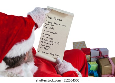 Santa Claus Reading A Letter Against White Background