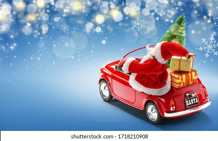 Santa Claus In Red Car Delivering Gift Boxes And Christmas Tree On Blue Background With Bokeh Lights