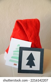Santa Claus red hat with christmas postcards on a table at home - Shutterstock ID 2216142207