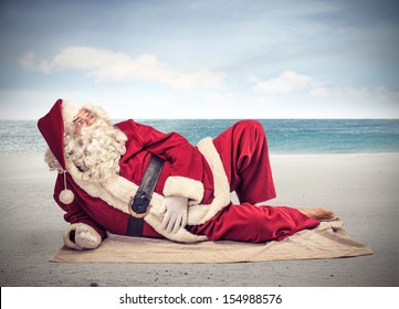 Santa Claus Relaxes Lying On The Beach