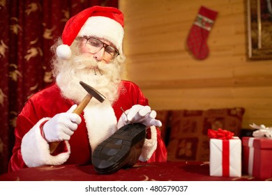 Santa Claus Repairing Shoe At The Table