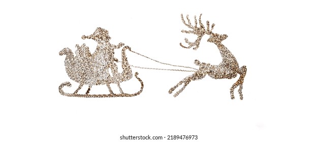 Santa Claus riding on a sleigh pulled by a reindeer. Handmade Santa silhouette made of gold sequins on a white paper background. Template for creating a Christmas or New Year's design - Powered by Shutterstock