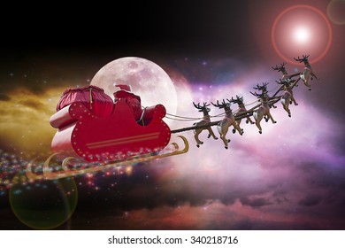 Santa Claus riding a sleigh led by reindeers following the star 