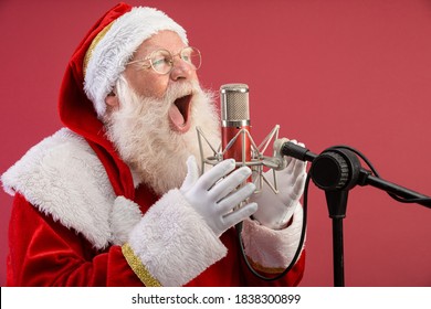 Santa Claus singing or speaking in a studio microphone. Merry Christmas. Broadcaster. Announcer. Promotion. Christmas music concept. - Powered by Shutterstock