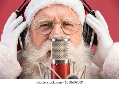 Santa Claus singing or speaking in a studio microphone. Merry Christmas. Broadcaster. Announcer. Promotion. Christmas music concept. - Powered by Shutterstock