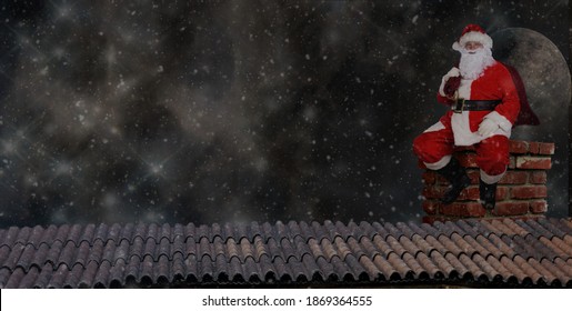 Santa Claus sitting on a rooftop chimney with with his bag over his shoulder, moon, stars and snow effect background. Panorama format with copy space. - Powered by Shutterstock