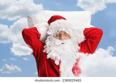 Santa claus sleeping on a white pillow with clouds and blue sky in the background - Powered by Shutterstock