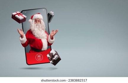 Santa Claus in a smartphone screen and Christmas gifts, online shopping app concept - Powered by Shutterstock