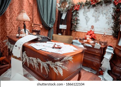 Santa Claus Table With Christmas Mail Letters And Vintage Decor On Holiday Eve In Cozy Santa Home Workshop Interior On Xmas. Santa's Work Room