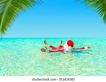 Santa Claus Take Pleasure Swimming  In Ocean Water At Palm Beach, Christmas And New Year Vacation In Hot Countries Concept