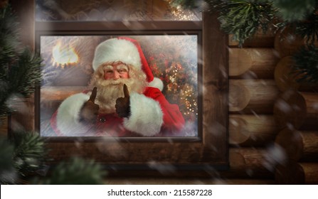 Santa Claus Thumbs Up Through His Workshop Window In The North Pole To See Outside. Christmas Eve