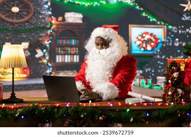 Santa Claus uses a laptop in his festive log cabin navigating online webpages to track gifts. The North Pole is filled with Christmas magic as Saint Nicholas embraces the digital age.