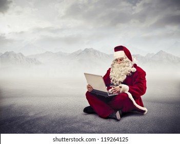Santa Claus using a laptop computer in a wasteland