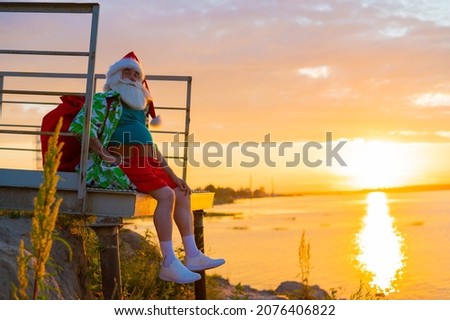 Santa Claus is walking on the beach at sunset