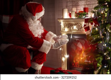 Santa Claus Warming His Hands At Fire Fireplace.