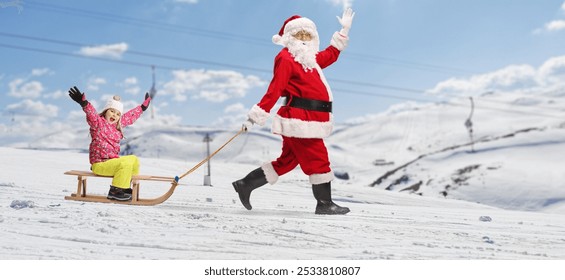 Santa Claus waving and pulling a girl with a sled on a snowy hill - Powered by Shutterstock