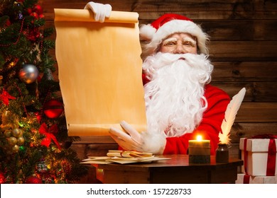 Santa Claus In Wooden Home Interior Holding Blank Wish List Scroll