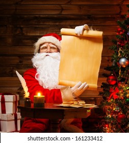 Santa Claus In Wooden Home Interior Holding Blank Wish List Scroll