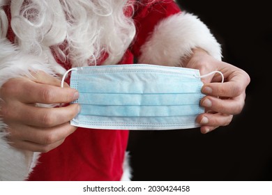 Santa Clause Hands Holding Coronavirus Surgical Blue Face Mask. Covid Christmas And New Year 