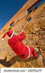 Santa Climbing A Wall While A Scary Halloween Monster Is Waiting For Him