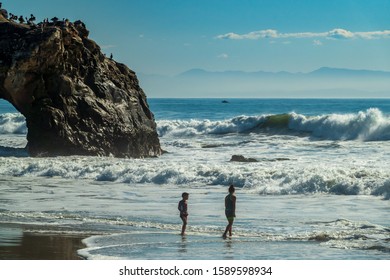 Santa Cruz, CA/USA-November 23,2019-Kids On The Beach At Natural Bridges Santa Cruz, Big Waves