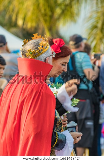 SANTA CRUZ DE TENERIFE, SPAIN - FEBRUARY 25, 2020:\
Around the Coso parade - along the Avenida de Anaga, official end\
of Carnival. Amazing warm evening, joyful people in carnival\
costumes have fun.