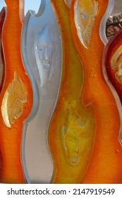 Santa Fe, New Mexico, U.S.A.-April 17,2022; Faces In Colorful Orange White And Yellow Glass Of Art Installation By Raya Friday At Santa Fe Botanical Gardens Vertical Format Room For Type