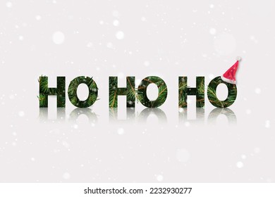 Santa ho ho ho sound made of a fir branch with Santas hat in the end. Winter Christmas background with snow.