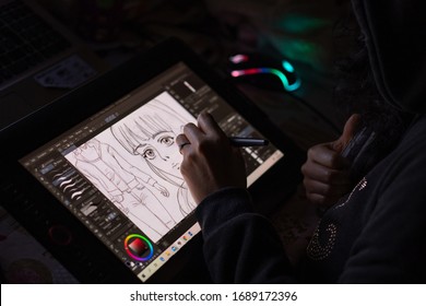 Santa Maria C.V., Italy, March 31th 2020, Artist female doing a manga design with a digital Wacom tablet