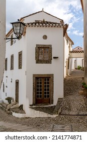 Santa Maria de Marvao, Portugal - 30 March, 2022: vertical view of a cobblestone street and historic whitewashed houses in the old city center of Marvao