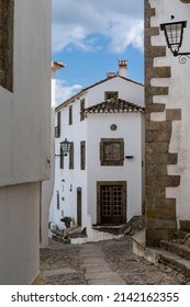 Santa Maria de Marvao, Portugal - 30 March, 2022: vertical view of a cobblestone street and historic whitewashed houses in the old city center of Marvao