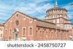 Santa Maria delle Grazie timelapse with blue cloudy sky. Milan, Italy. People walking around. Traffic on the road. This church and the adjacent Dominican convent were built during the 15th century.