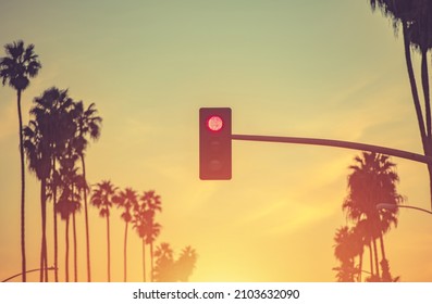 Santa Monica California Red Light and Palm Trees Conceptual Photo. United States of America. Scenic Sunset Warm Color Grading.