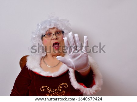 Santa must have been getting frisky.
Mrs Claus has an annoyed look on her face and is giving the Stop signal with her hand.