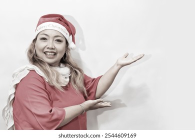 Santa woman showing copy space standing in red Santa hat. Isolated on white background. Asian woman smiling. Christmast concept, Copyspace - Powered by Shutterstock