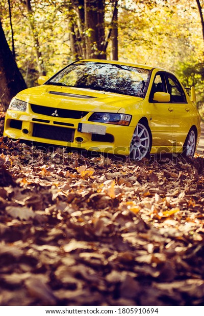 Santander,\
Cantabria / Spain, 11-18-2018: Mitsubishi Lancer Evolution 9, shot\
in a mountain road full of autumn\
leaves