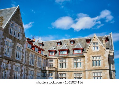 SANTANDER, SPAIN - JUNE 15, 2019 Palace De La Magdalena, Eclectic Residence Of Spanish Royalty With Low Angle View Showing Multiple Windows, Gray Roofs And Patch Of Blue Sky With White Clouds