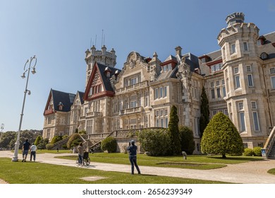 Santander, Spain. Spring view of the Palacio de la Magdalena with its grand facade, lush green lawn, and clear blue sky, once the royal summer residence of the Spanish monarchy