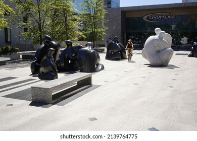 Santiago - Chile - February 10, 2022: bicycle riding between white and black statues representing persons kissing (modern public square in front of Costanera center).
