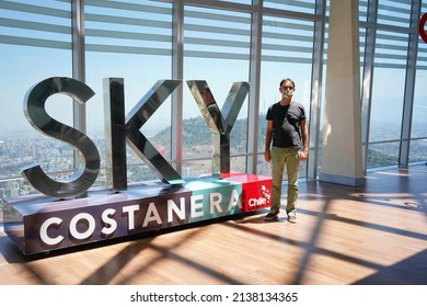 Santiago - Chile - March 05, 2022 - Portrait of an adult male next to "SKY" symbol at the roof top of the Costanera tower center.