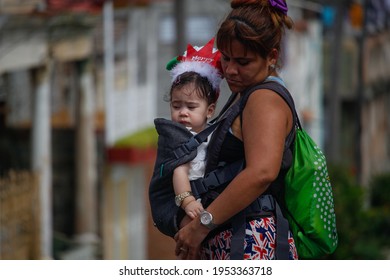 Santiago De Cuba, Cuba; 04.02.2020: A Woman Carries Her Young Daughter And Walks Through The Streets Of Santiago De Cuba. Everyday Life In Cuban Cities. 