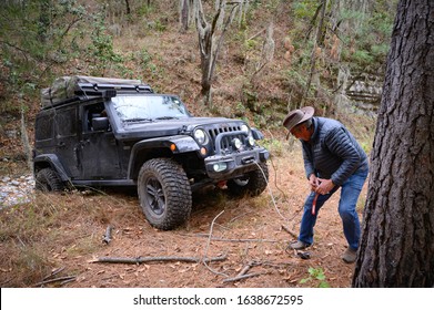 Santiago Nuevo Leon, Mexico. February 2, 2020. A Man Is Helping To  Climb An Obstacle  A Jeep With  The Vehicle Winch.