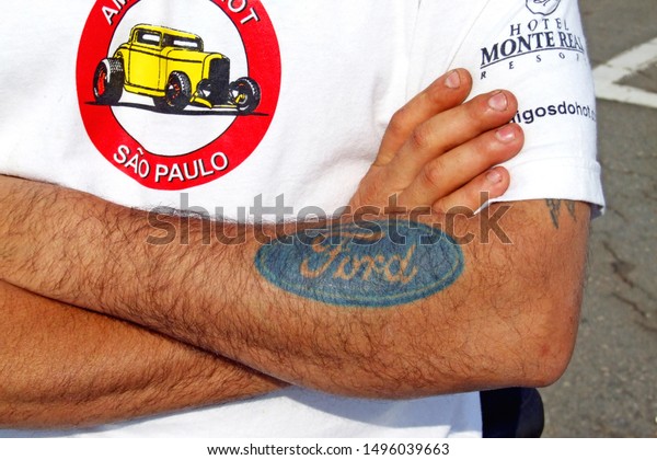 Santo\
André/SP/Brazil - 06-24-2007: Man with tattoo on Ford brand arm.\
Man fan of Ford cars with tattoo on his arm. Visitor of a car\
exhibition in the city of Santo André -\
SP.