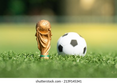 Vitória, Espírito Santo, Brazil - March 25, 2022 -  Copy Of Soccer World Cup Trophy On Soccer Field Lawn. A Soccer Ball In The Background