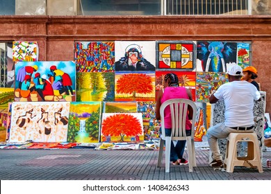 SANTO DOMINGO - DOMINICAN REPUBLIC - January 13, 2019 : Street Salers Of Caribbean Art When People Pass By In Old Town Also Called Zona Colonial Of Santo Domingo Dominican Republic.