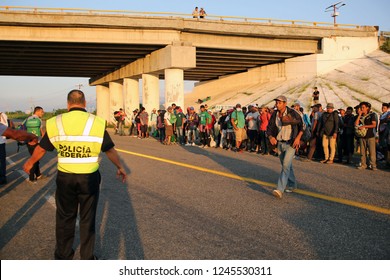 Santo Domingo Ingenio, Oaxaca/Mexico - Nov. 8, 2018: A Mexican Federal Police Officer Monitors Hondurans Fleeing Poverty And Gang Violence And Waiting For A Ride In The Second Caravan To The U.S. 