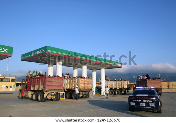 Santo Domingo Ingenio, Oaxaca/Mexico - Nov. 8,\
2018: Hondurans fleeing poverty and gang violence in the second\
caravan to the U.S. in dump trucks escorted by Federal Police stop\
at a gas station.