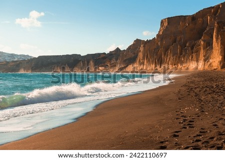 Santorini island, Greece. Vlichada beach with red volcanic pumice rocks. Blue sea and black volcanic sand. Famous travel destination