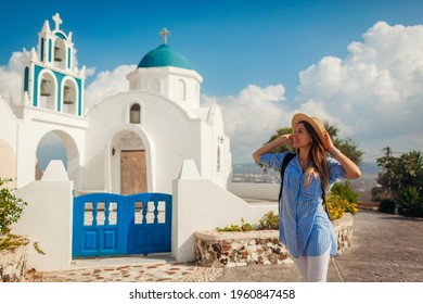 Santorini island traveler exploring greek church architecture in Akrotiri. Woman tourist walking during vacation. Traveling around Europe