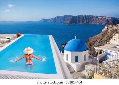 Santorini with Woman in the swimming pool in Oia village, Greece